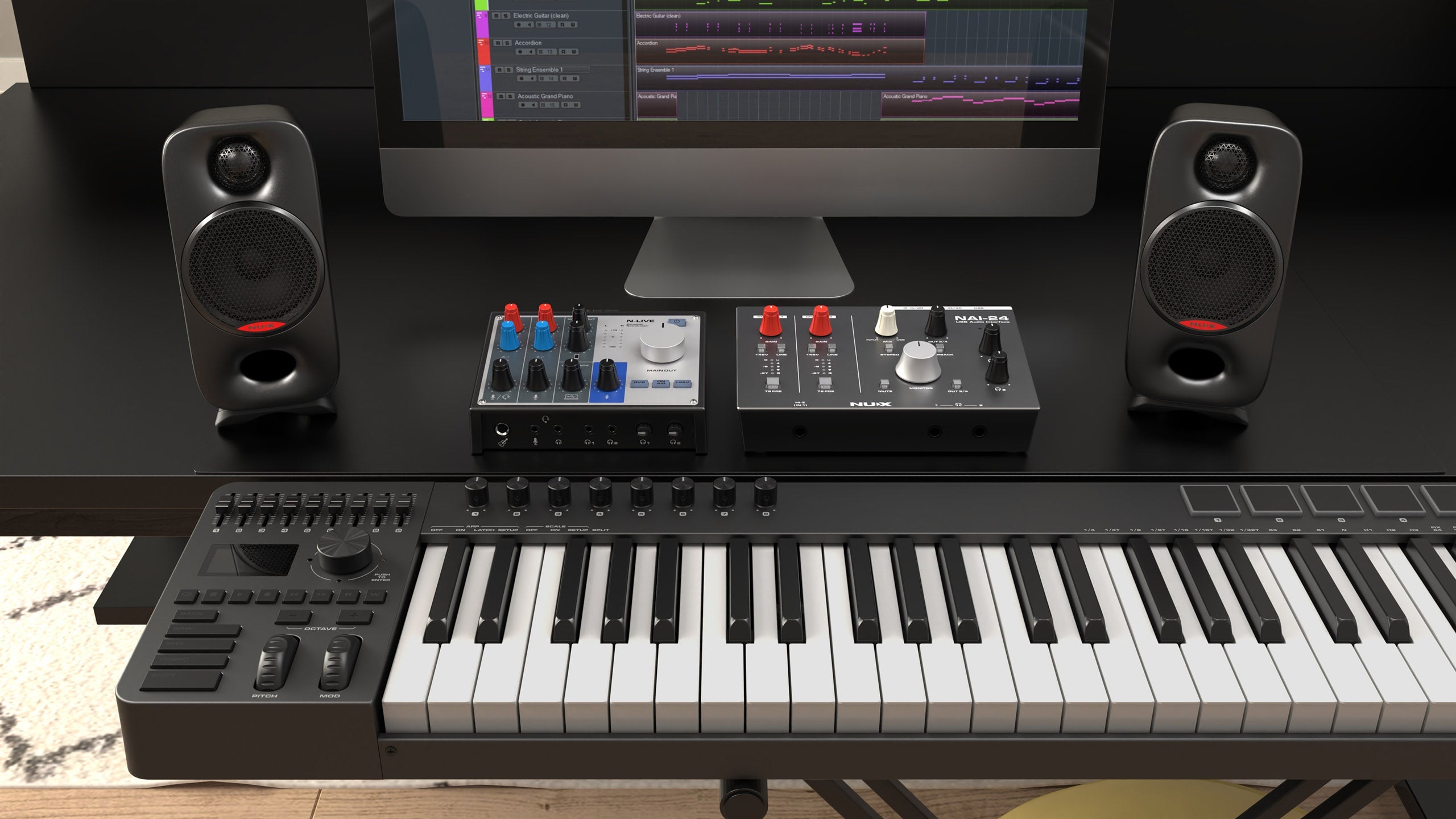 set of NUX studio midi setup with two speaker monitors in front of a computer screen.
