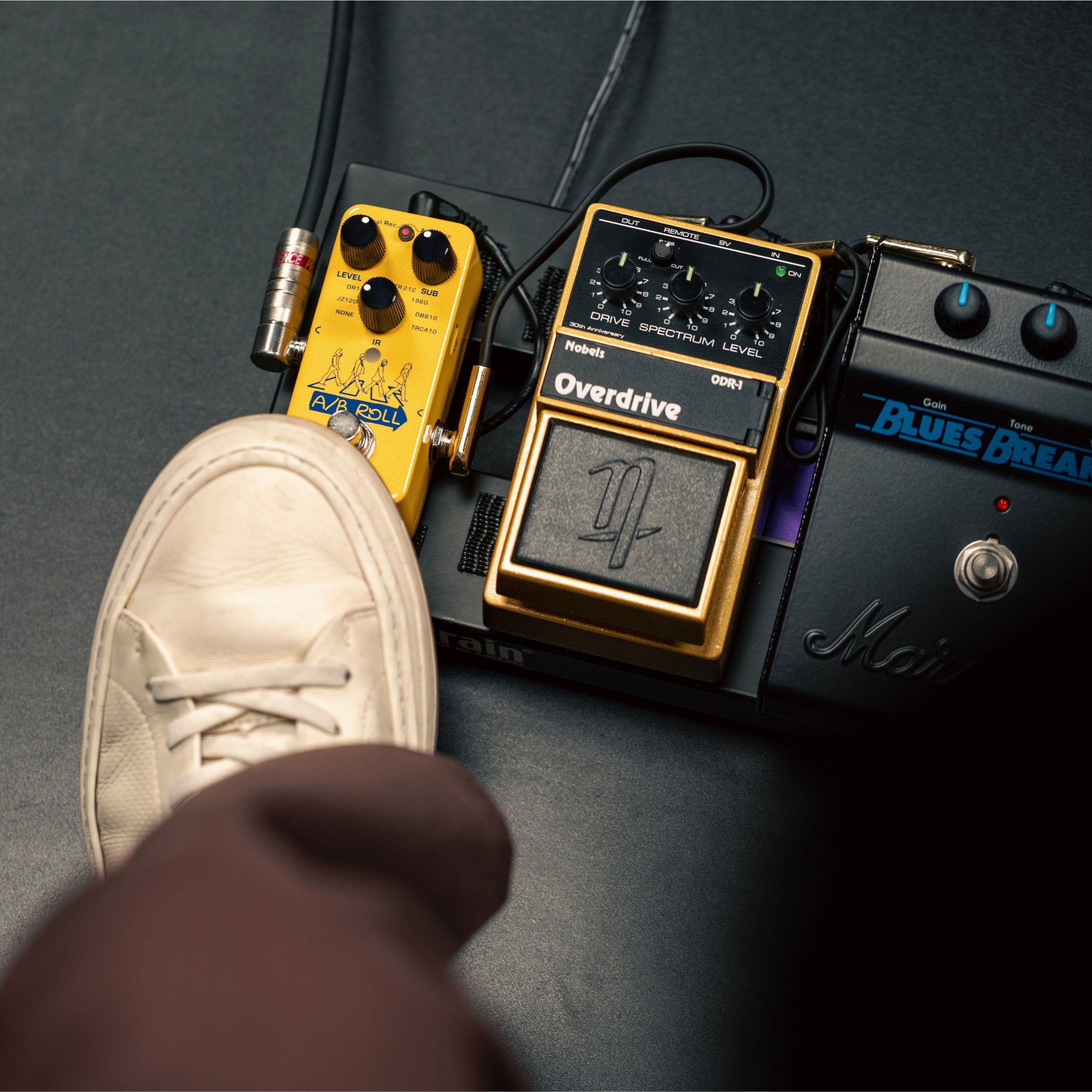 NUX A/B Roll mini core effects pedal with a foot stepping on the control pedal knob