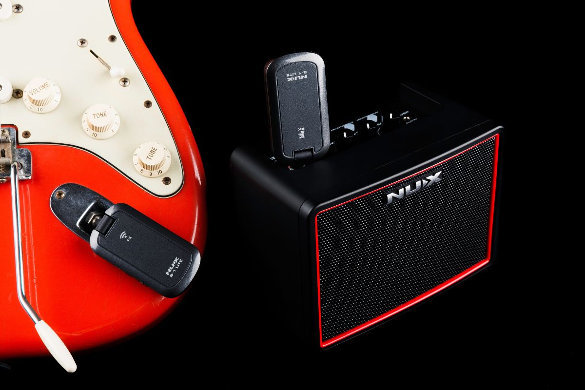 NUX B-1 Lite wireless guitar transmitter plugged into an electric guitar and with the receiver plugged into NUX Mighty Lite desktop amplifier.