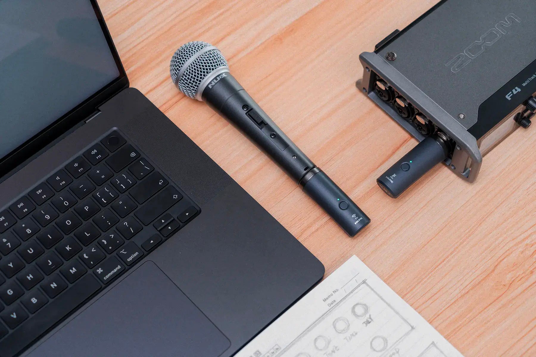 Laptop with NUX B-3RC wireless microphone kit and audio interface on a wooden surface