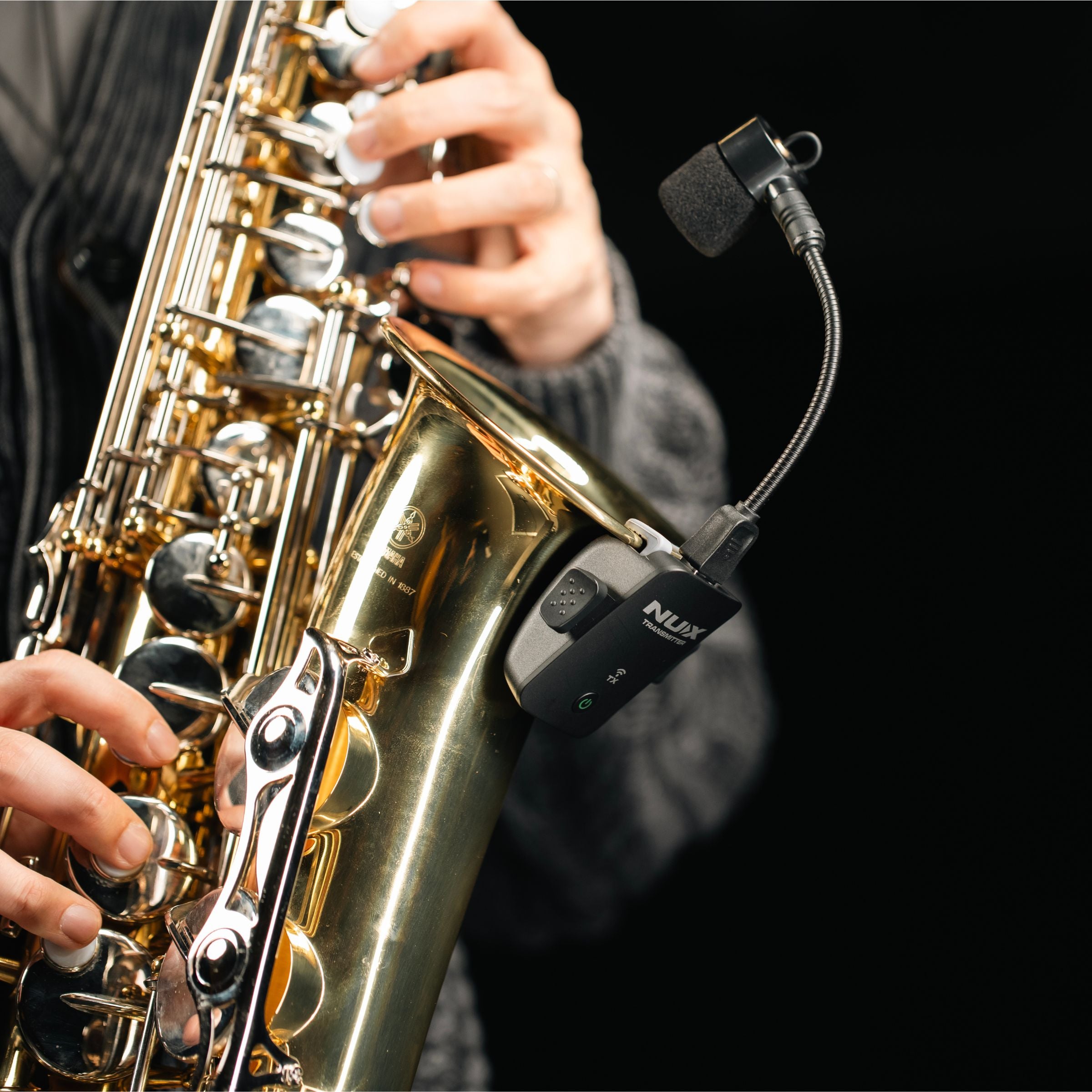 Person playing the saxophone equipped with NUX B-6 PRO wind instrument wireless system kit.