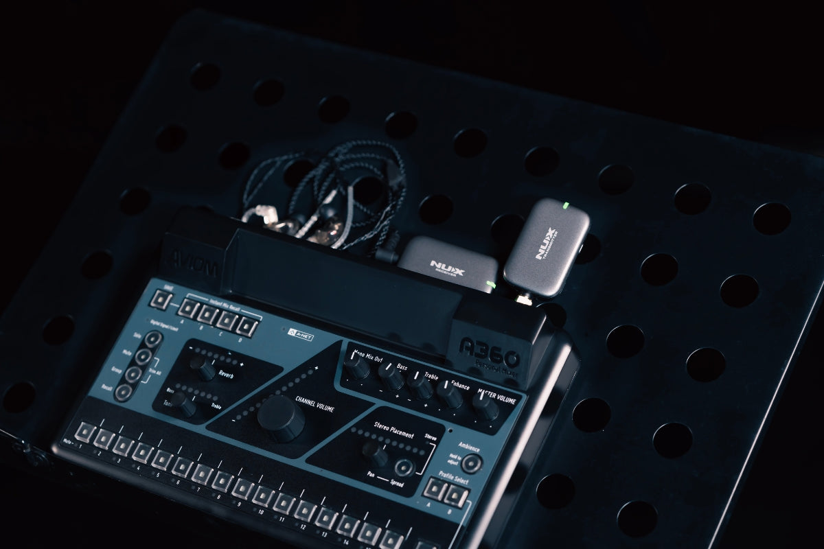 NUX B-7 PSM receiver plugged into an electronic music synthesizer on a perforated surface with cables