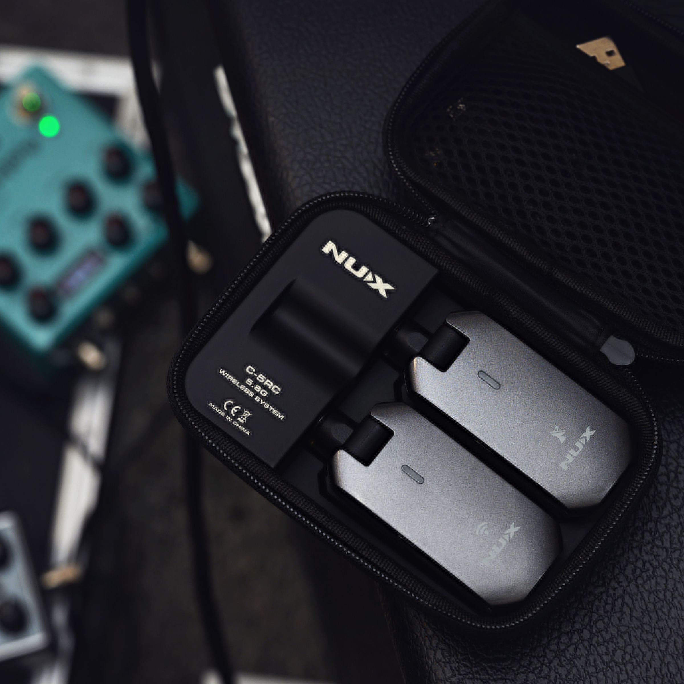 NUX C-5RC wireless transmitter and receiver inside the included portable charging case on an amp.