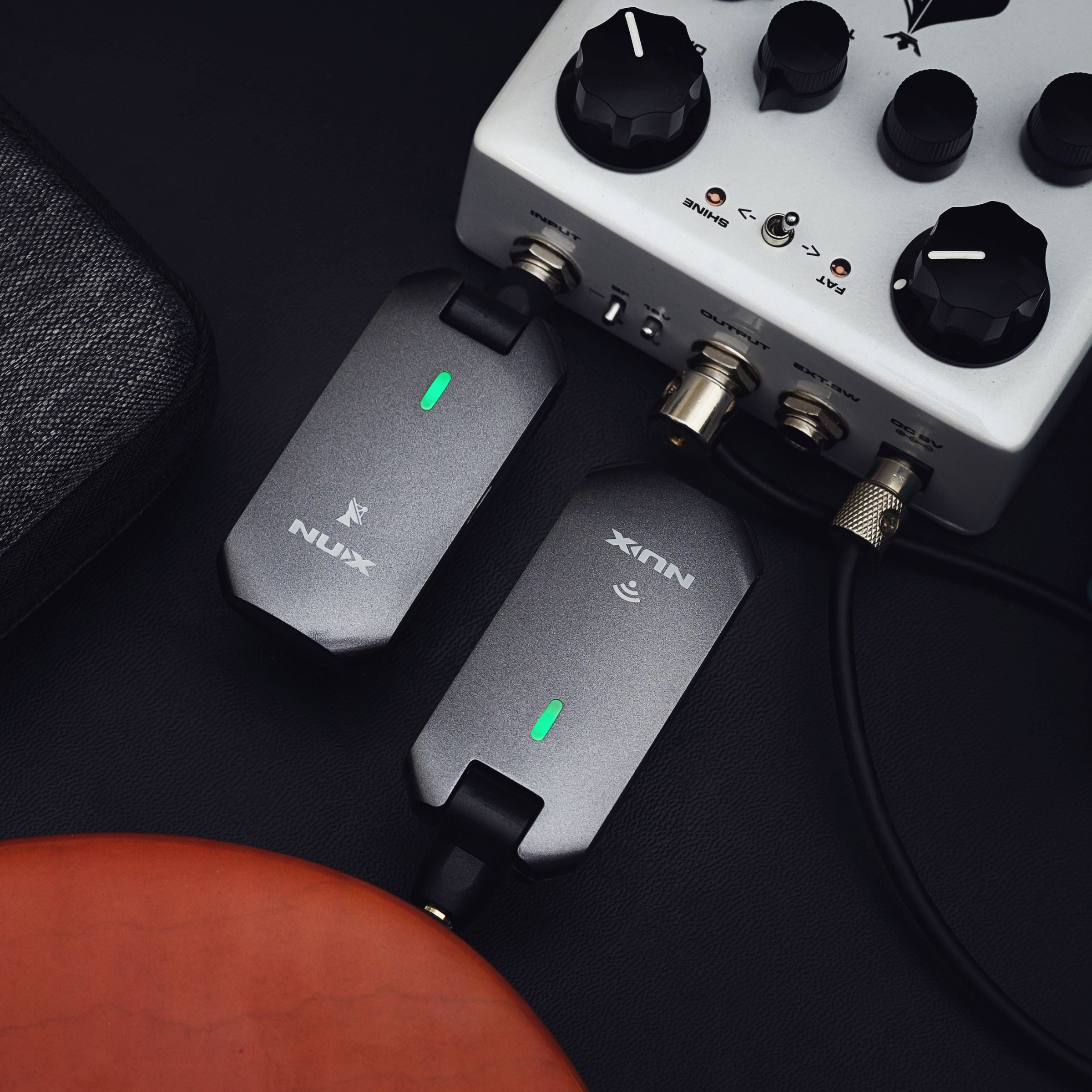 Guitar effects pedal with NUX C-5RC wireless guitar receiver plugged in and the transmitter plugged in to a guitar.