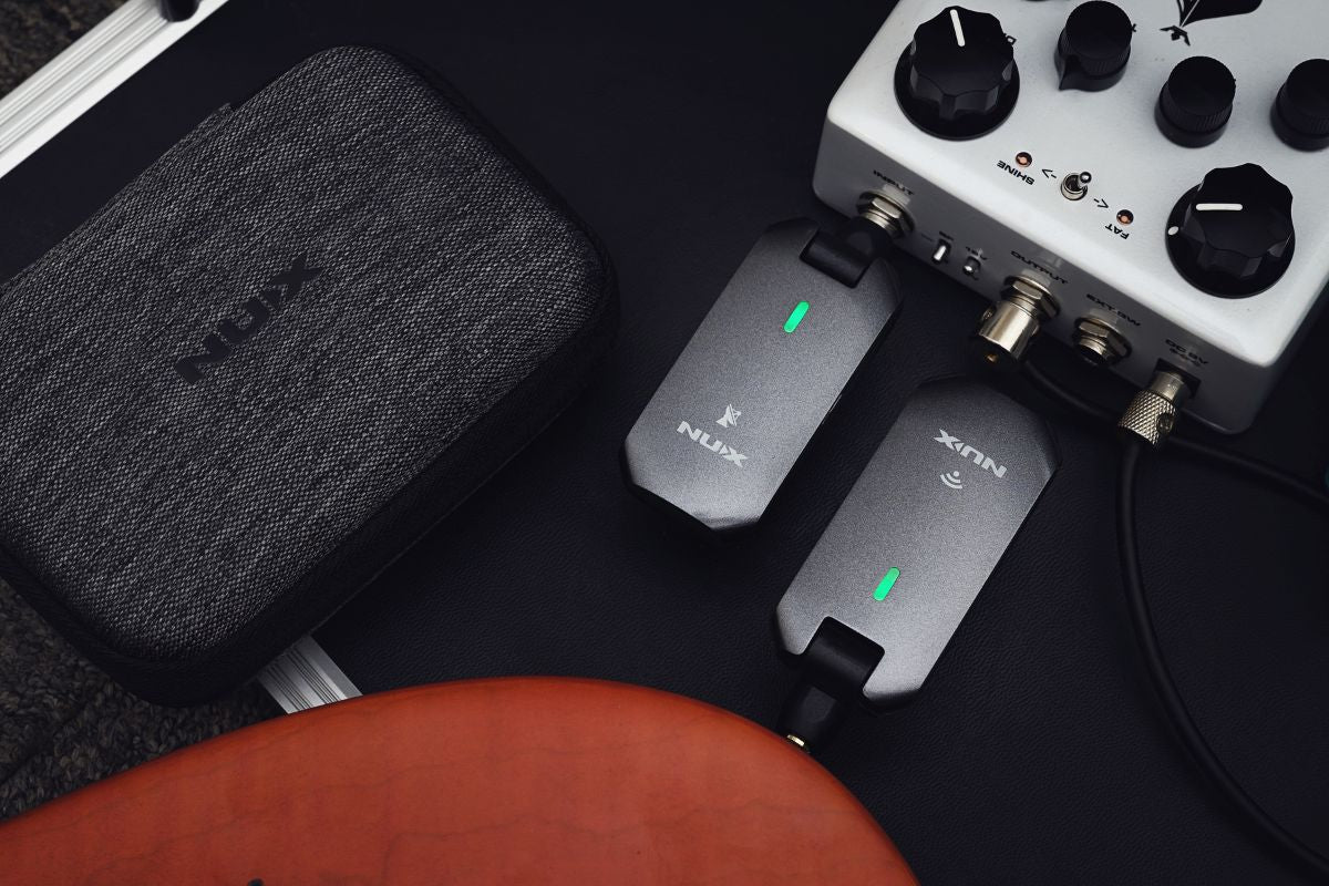 NUX C-5RC transmitter plugged into a guitar and receiver into a sound mixer
