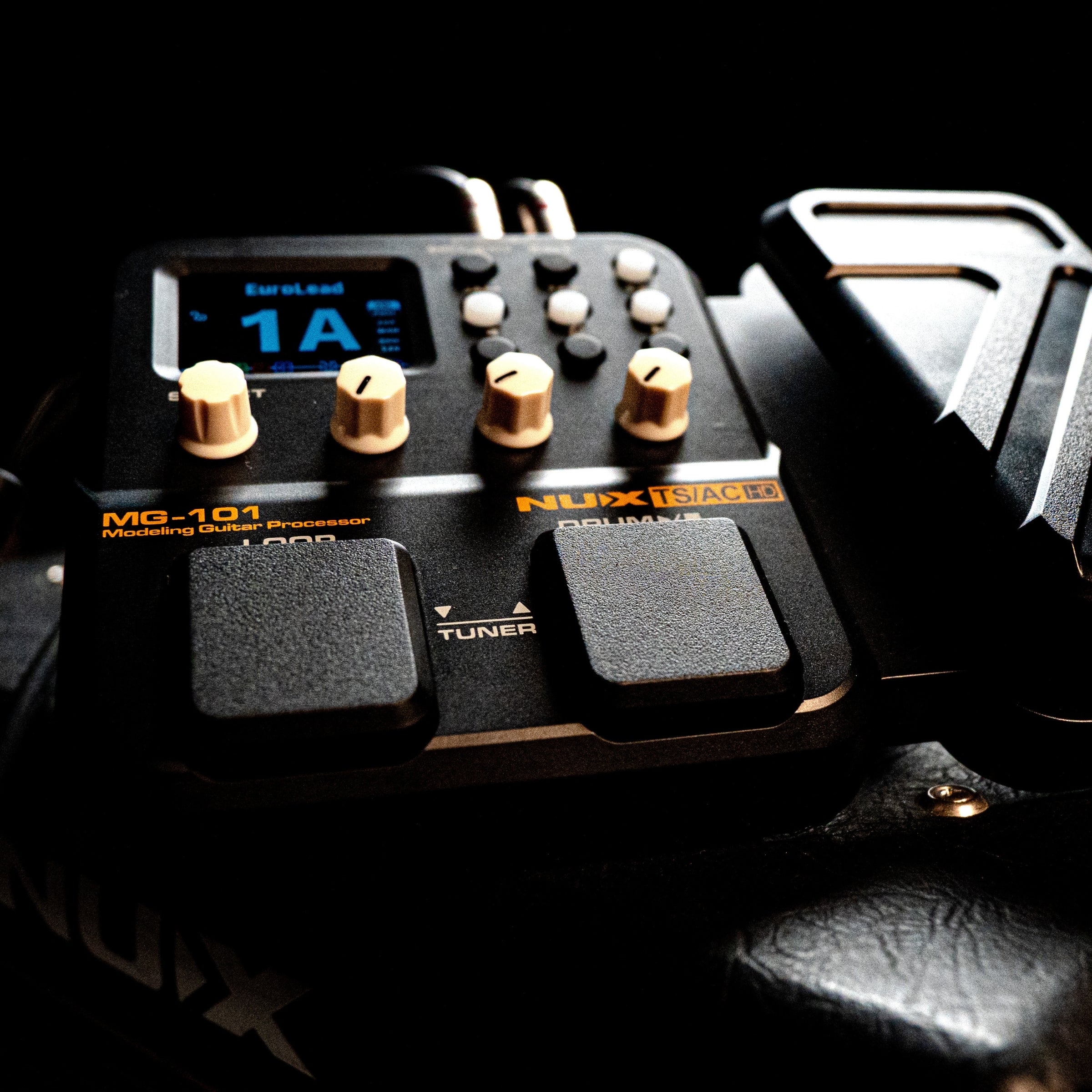 Nux MG-101 modeling guitar processor with visible branding on a dark background