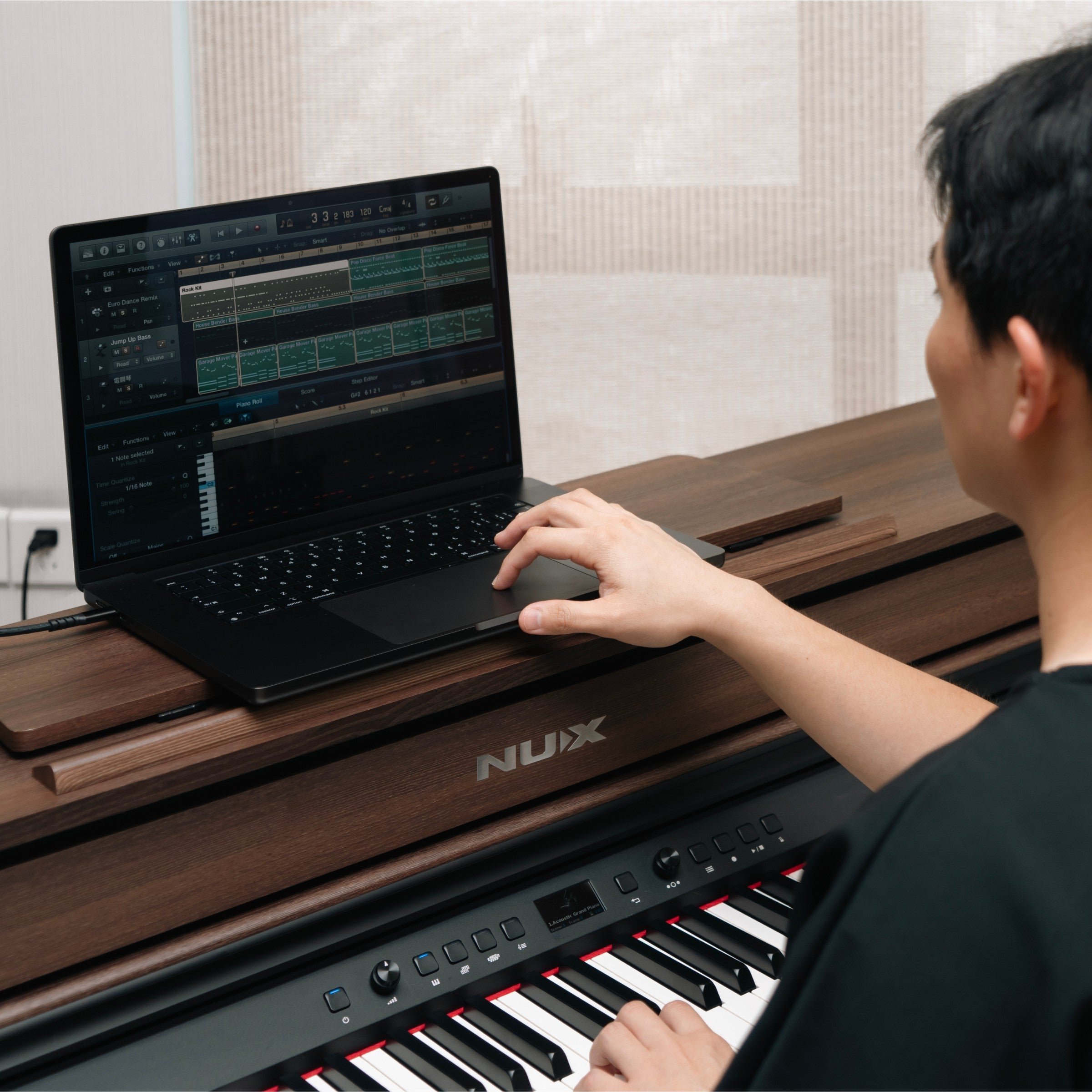 Person using a laptop on a NUX music stand with a piano in the foreground