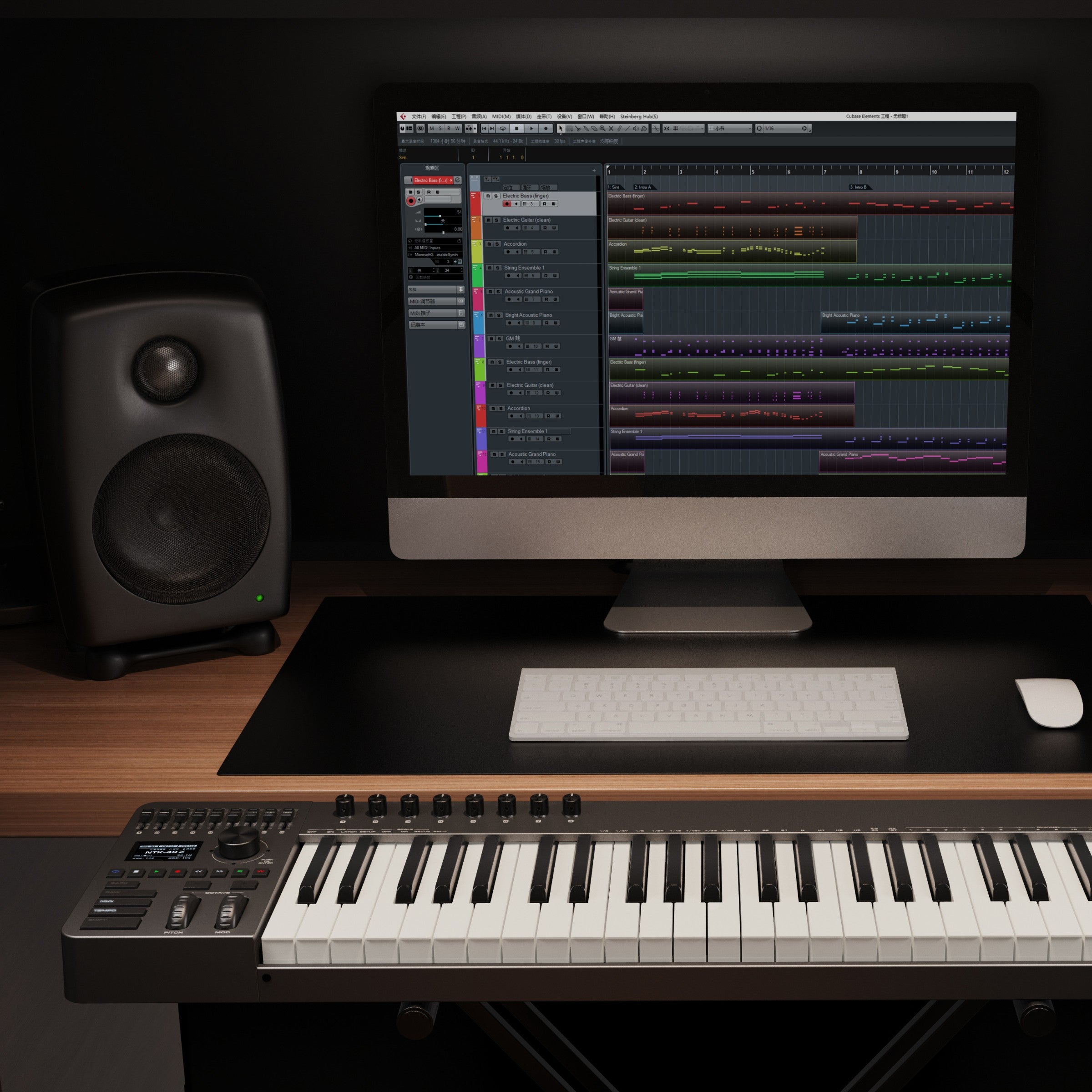 Music production setup with computer, NUX MIDI keyboard, and speakers on a desk.