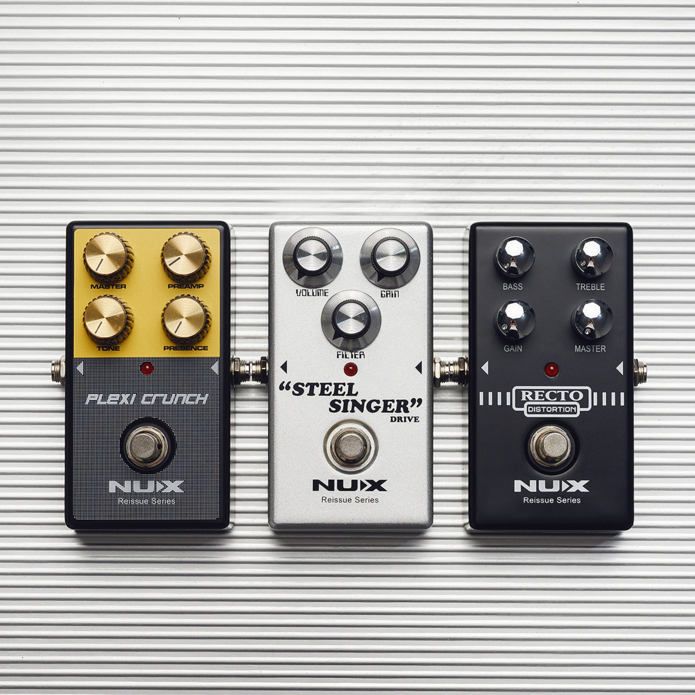 Three NUX guitar effect pedals on a striped background