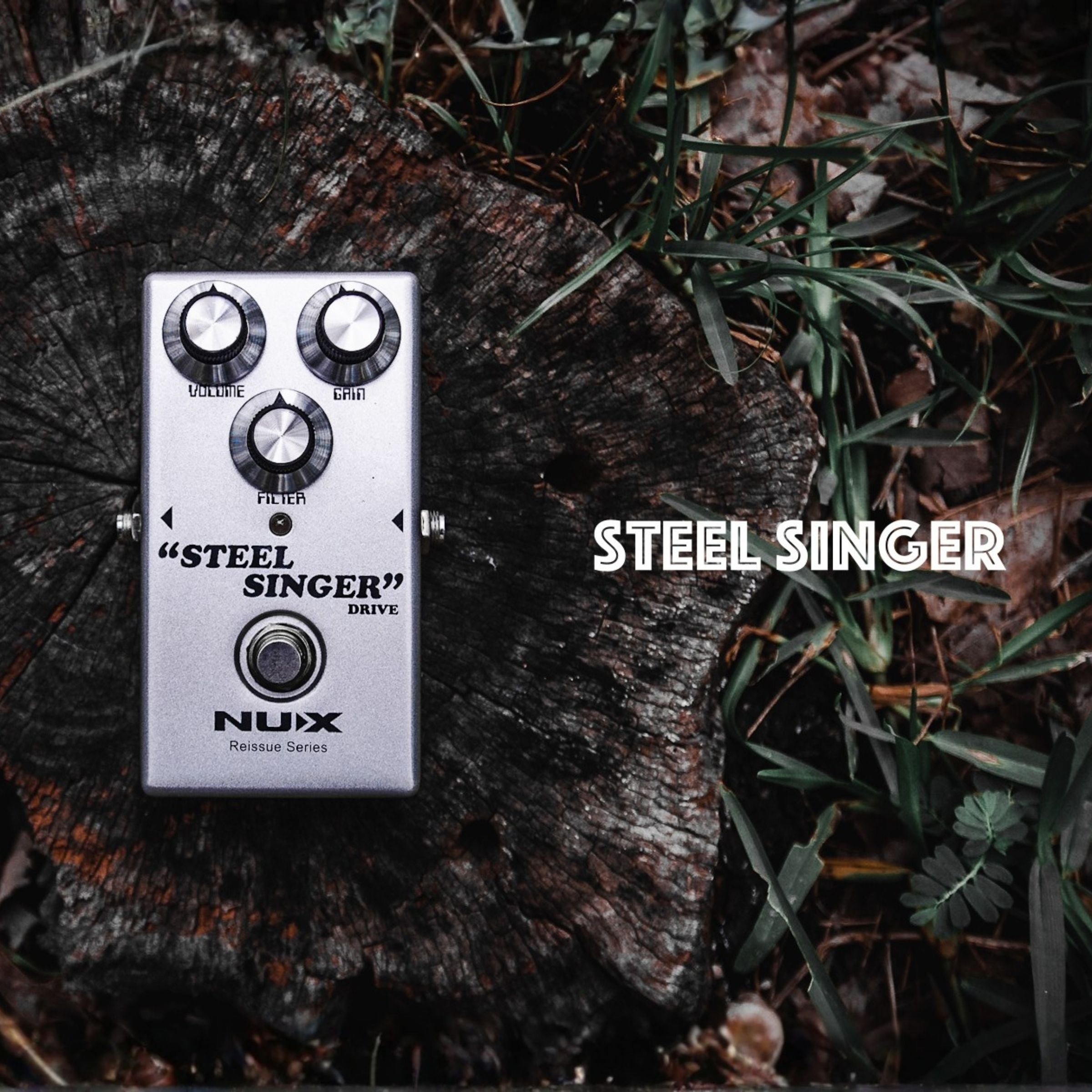 Nux Steel Singer guitar effects pedal on a wooden surface with grass.