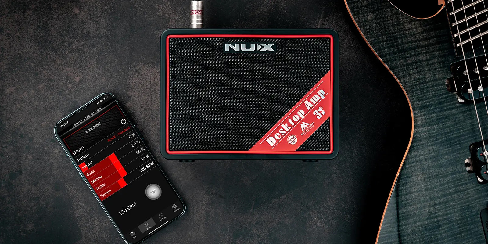 NUX guitar amp with smartphone app on a dark surface