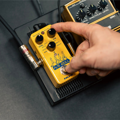 NUX A/B Roll mini core effects pedal with hand on the sub control knob