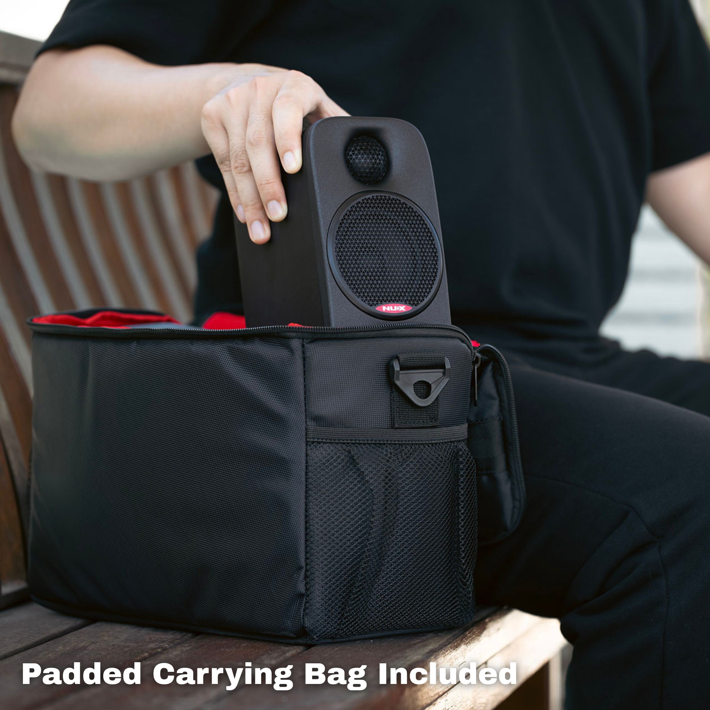 Person holding a black speaker above a black carrying bag with 'Padded Carrying Bag Included' text.