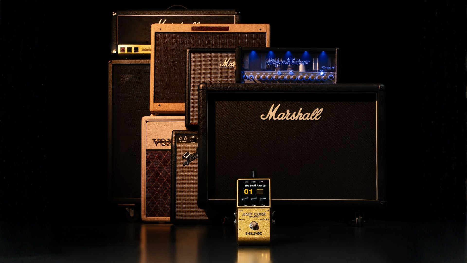 Collection of guitar amplifiers and effects pedals on a dark background