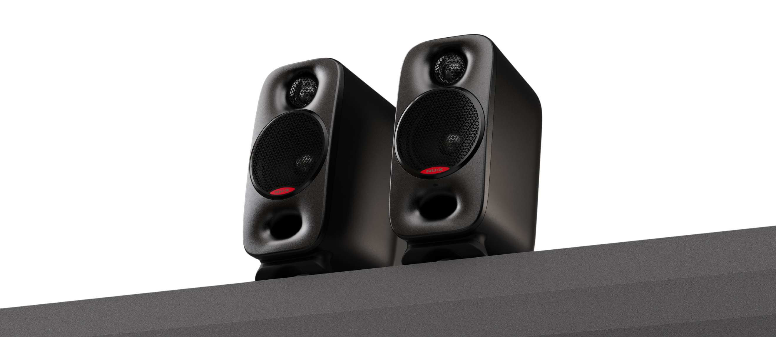 Pair of black NUX Axon speakers on a white background