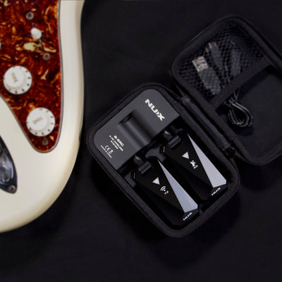 NUX B-5RC wireless guitar system in a portable charging case next to an electric guitar in white background.