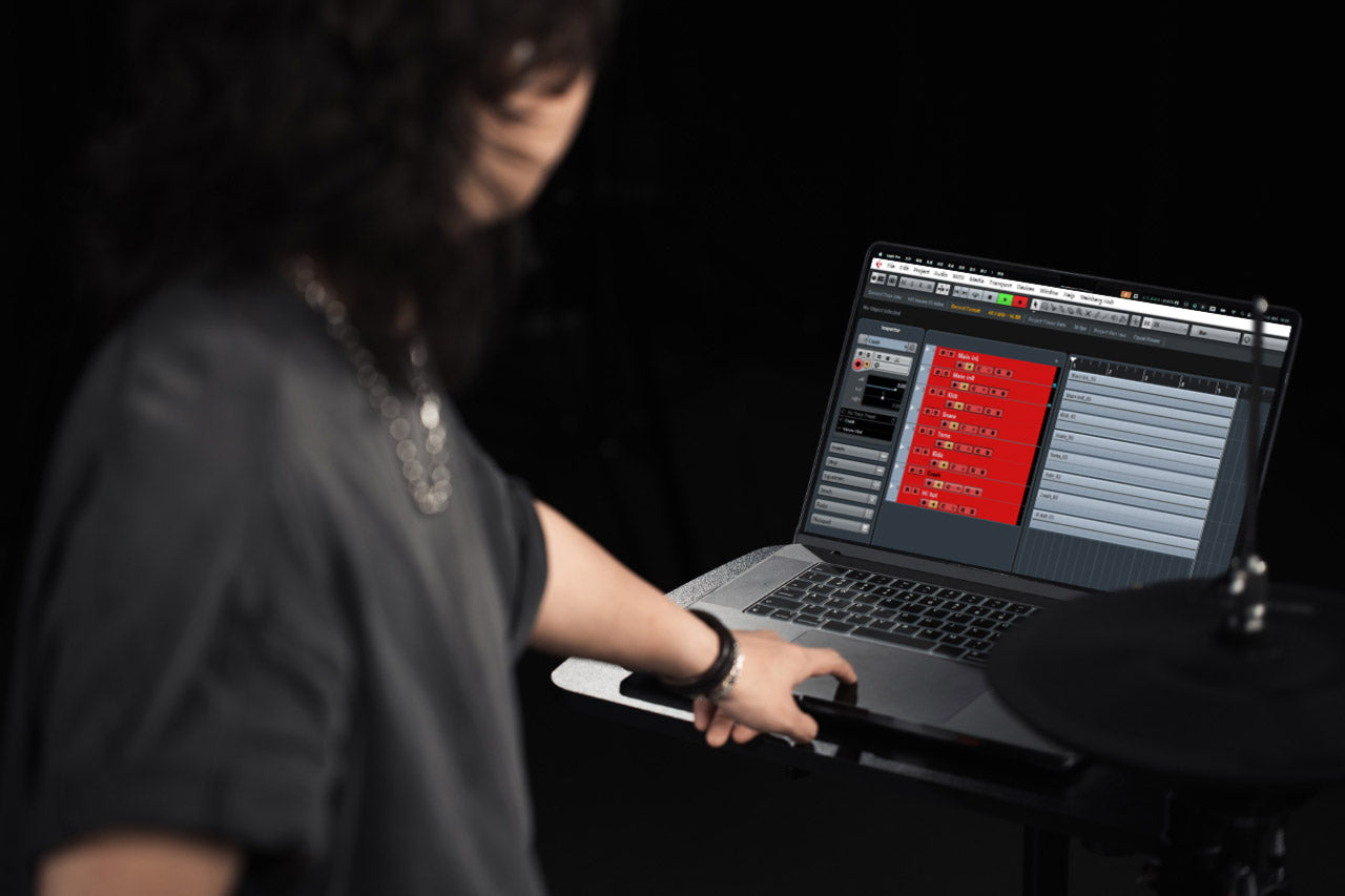 Person using laptop with music editor app connected to NUX drum kit