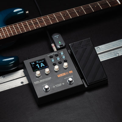 NUX MG-300 MKII on a floor next to a guitar