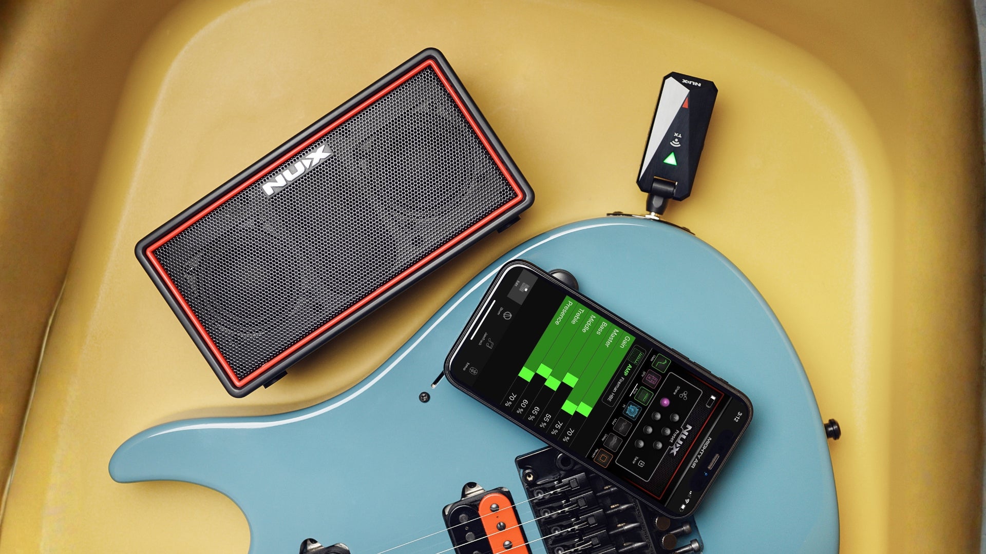 Smalle NUX Mighty air amp on a chair next to an electric guitar with a phone showing the app interface
