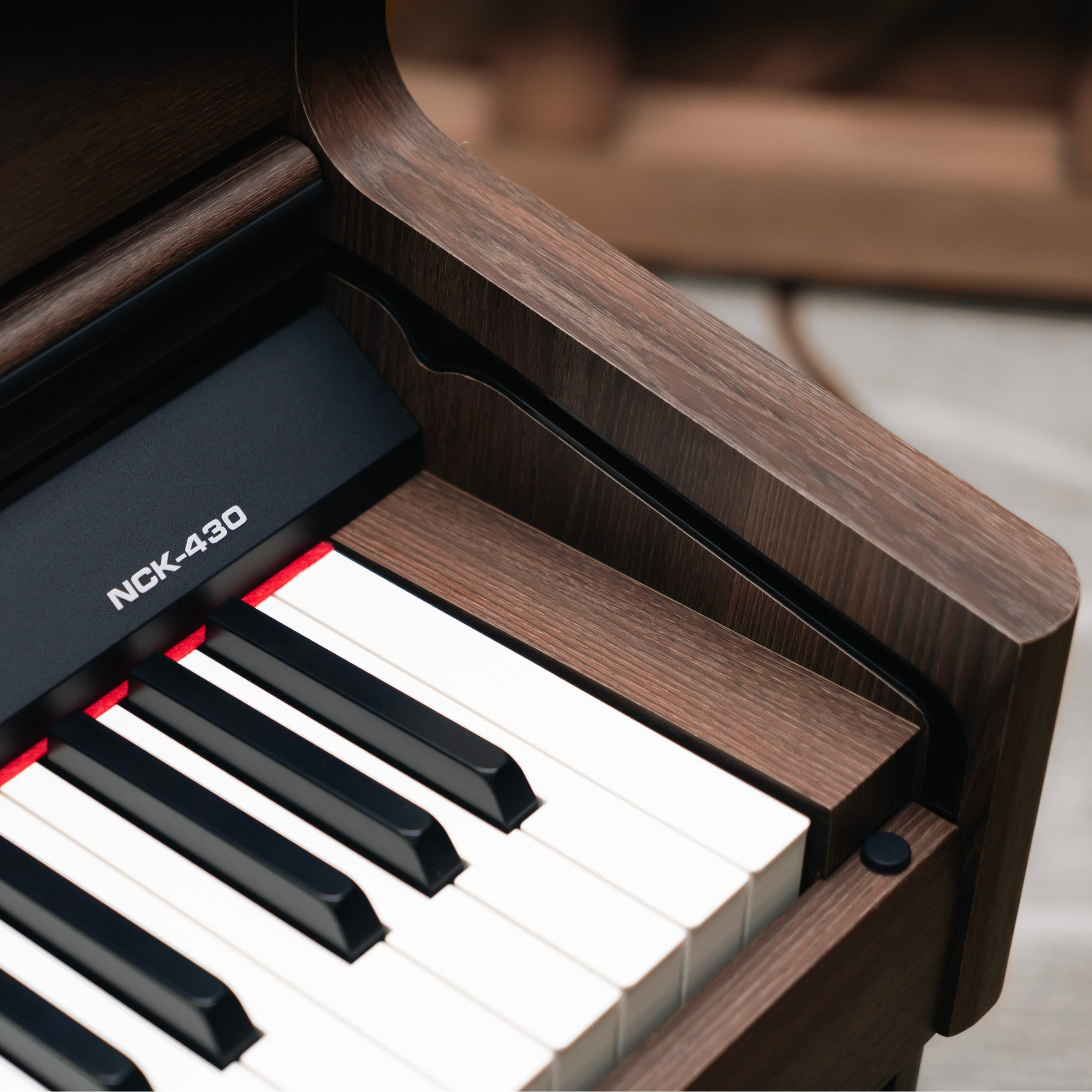 Close-up of a digital piano with wooden finish and NCK-430 branding.