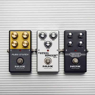 Three NUX guitar effect pedals on a striped background