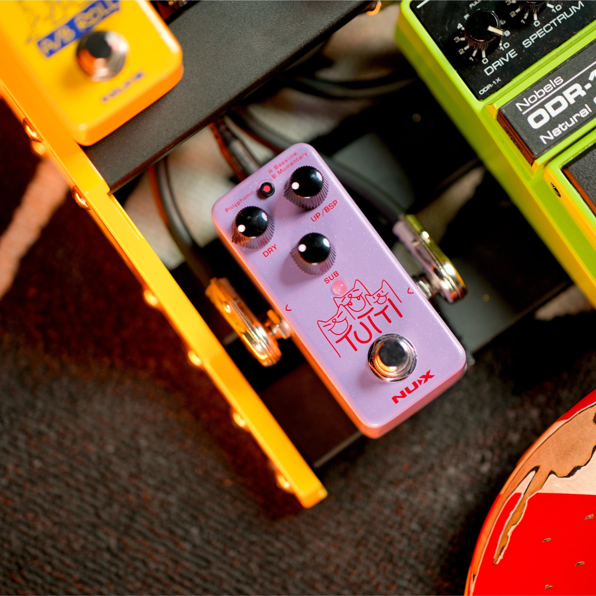 Close-up of guitar effect pedals on a guitar stand