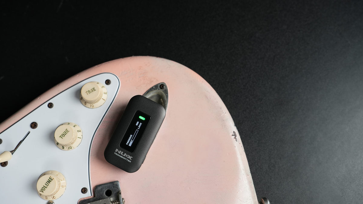 NUX C-58RC transmitter with built-in tuner plugged into a guitar