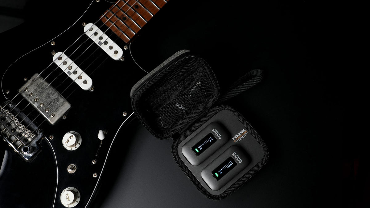 NUX C-58RC magnetic charging case open next to an electric guitar