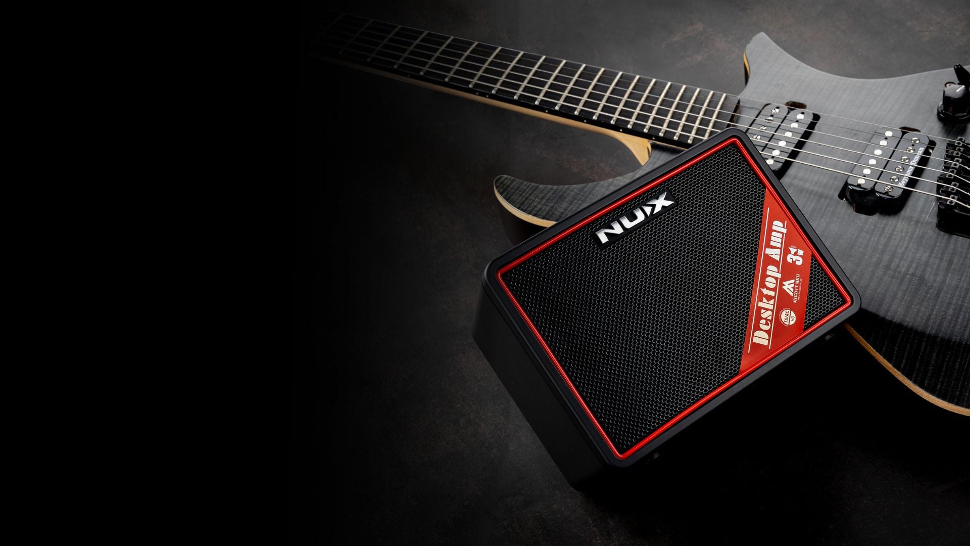 Nux small guitar amplifier with a guitar on a dark background