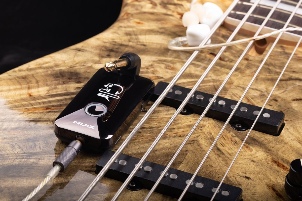 NUX mighty plug on top of an electric guitar