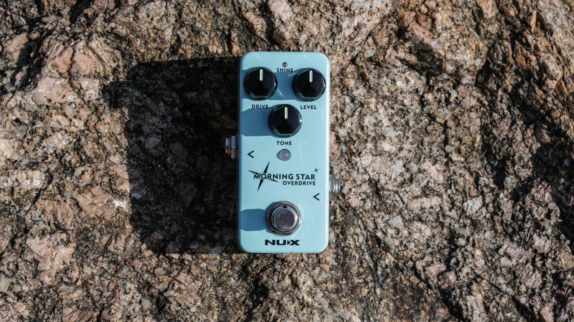 Small NUX Morning star blue guitar effects pedal on a textured brown surface