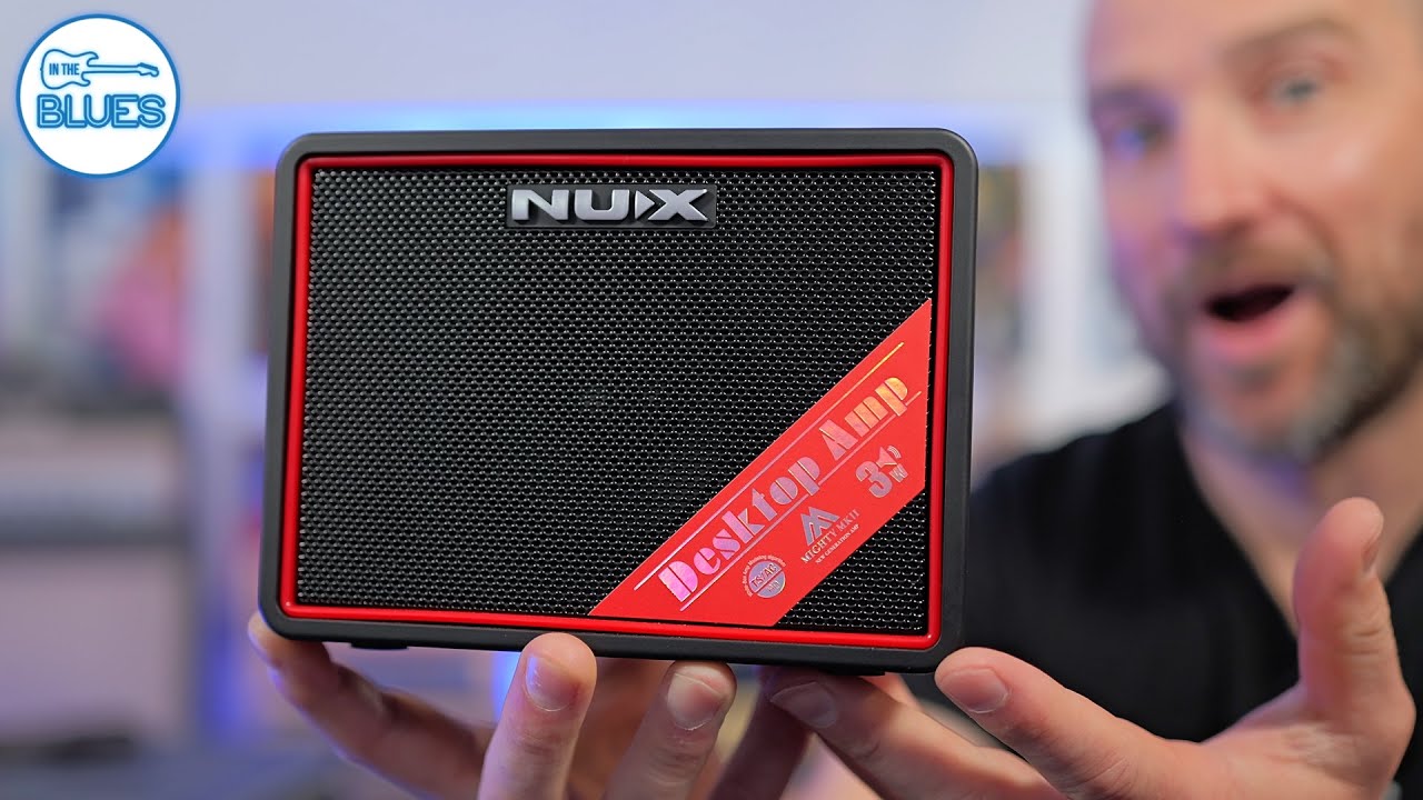 Person holding a Nux Desktop Amp with a blurred background